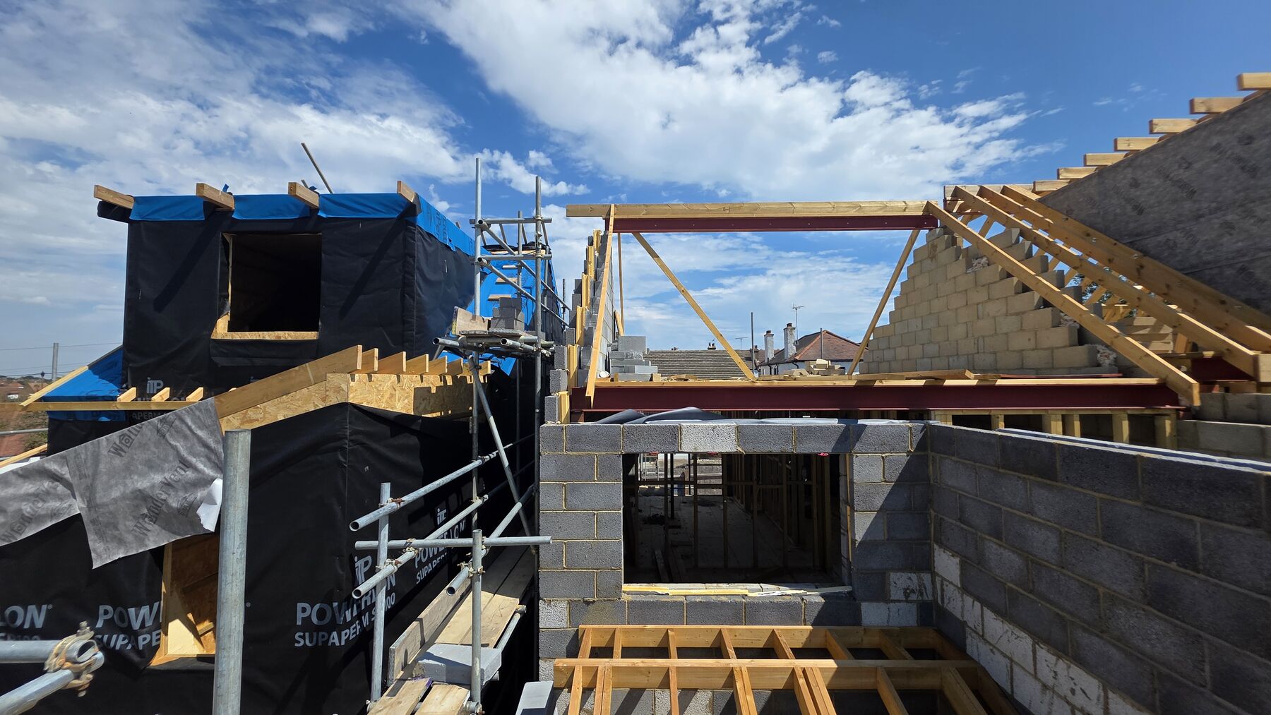 Steel beam supporting new roof timbers over blockwork walls