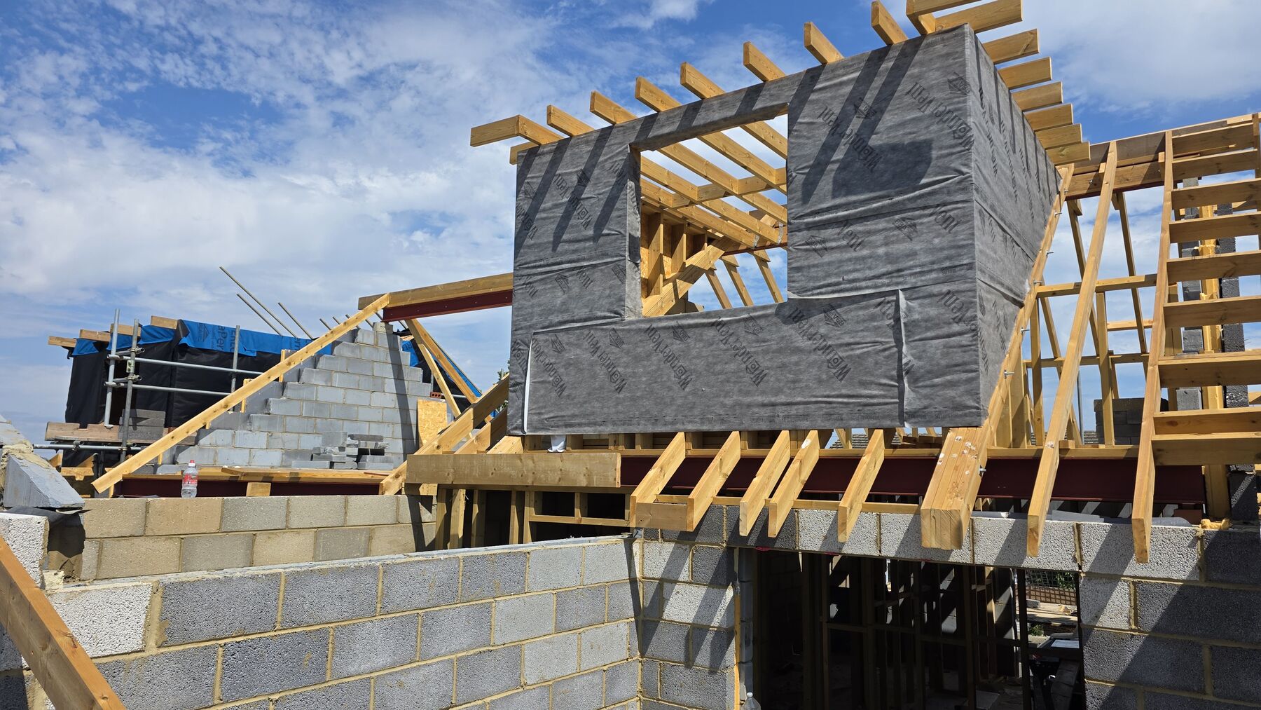 New timber roof carpentry and blockwork gable under construction at Cliffsea Grove