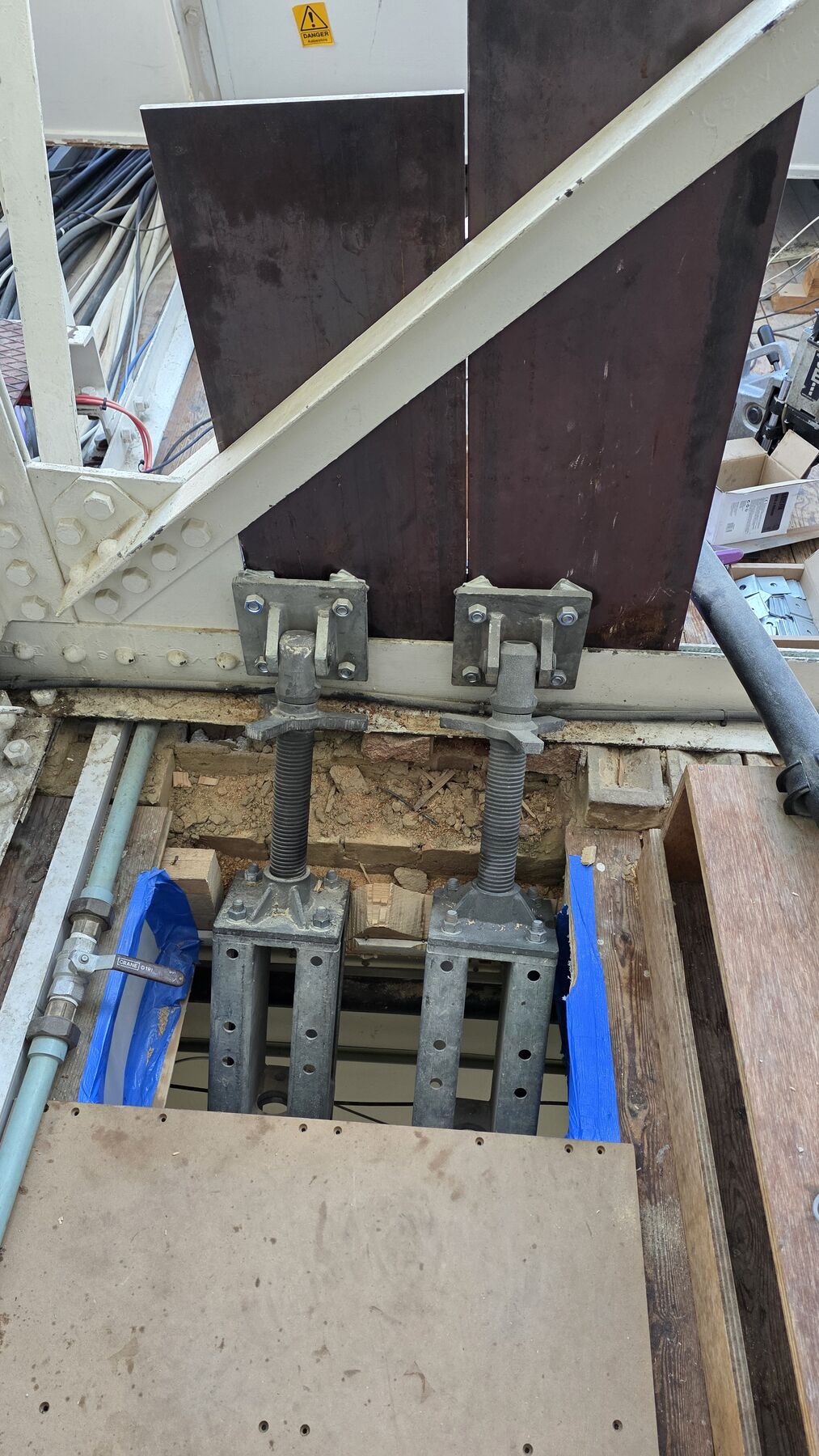 Needle beam installed through masonry with adjustable props during temporary works