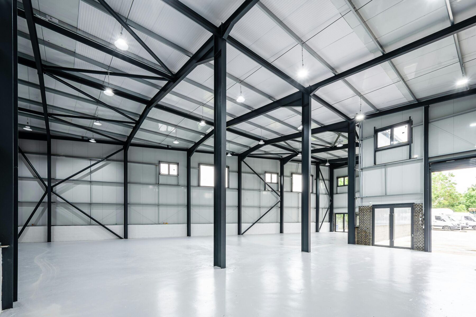 Clear-span interior of a steel portal frame unit showing columns, rafters and bracing