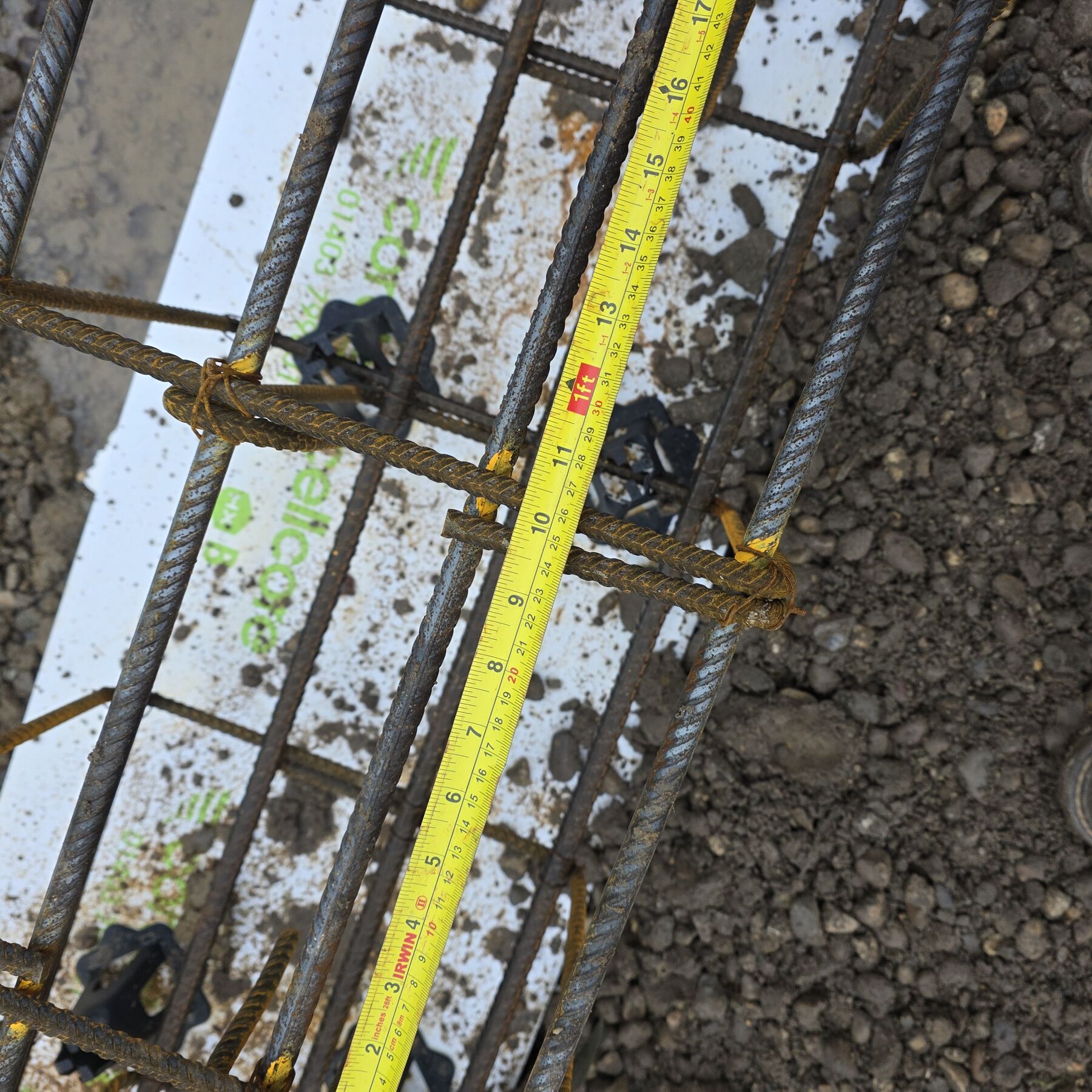 Reinforcement bars and spacers being measured before a concrete pour